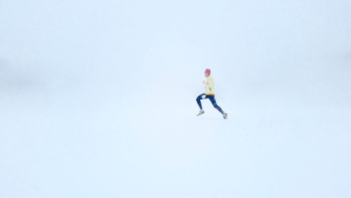 person wearing yellow jacket and black pants