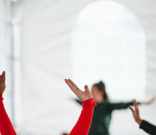 스트레칭으로 굳은몸을 풀어보 woman in red long sleeve shirt raising her hands