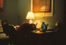만성피로, 단순한 피로 아냐… 일상까지 무너뜨리는 건강의 적 a person sitting at a desk in front of a lamp