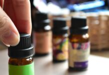 현대인의 일상 속 대체요법, 작지만 확실한 건강 루틴으로 인기 a hand touching a bottle of essential oils