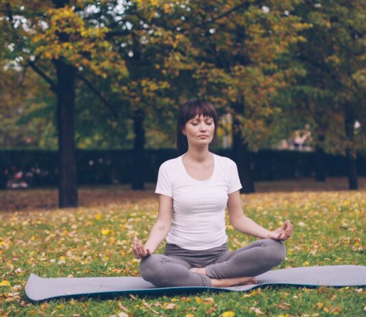 “움직이는 명상”… 뇌와 몸을 동시에 깨우는 ‘마인드풀 무브먼트’ Woman meditating in a park during autumn.