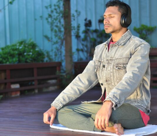 “스트레스, 일상 속 새로운 관리법 찾기 – 현실적인 실천 루틴이 인기” a man sitting on a table wearing headphones