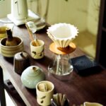 “바쁜 일상 속 ‘슬리포노믹스’ 열풍…똑똑하게 잠드는 생활 루틴이 뜬다” Various tea ceremony utensils arranged on a wooden table.