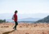 일상 속 ‘마음챙김 걷기’, 건강과 힐링을 한 번에 a man with a backpack walking across a dry grass covered field