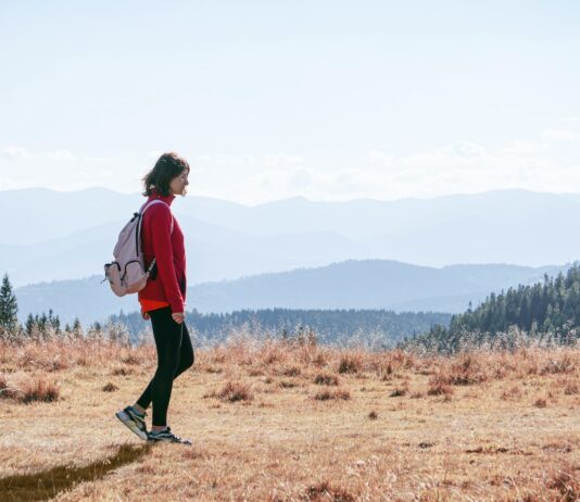 일상 속 ‘마음챙김 걷기’, 건강과 힐링을 한 번에 a man with a backpack walking across a dry grass covered field