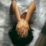 바쁜 일상 속 스트레스, 일상에서 실천하는 관리법 주목 a woman holds her hands over her face