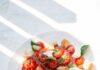 식단, 꾸준함과 균형이 답이다… 최신 건강 트렌드 살펴보니 sliced tomato and green leaf vegetable on white ceramic plate